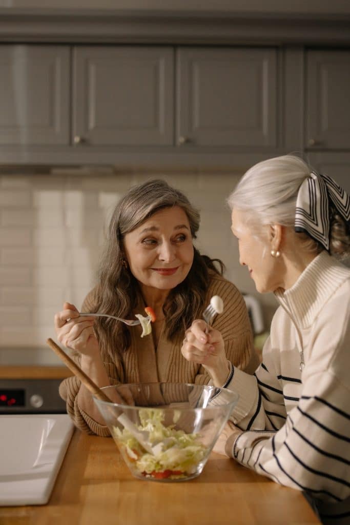 Femme âgée se regardant l'une l'autre en tenant une fourchette